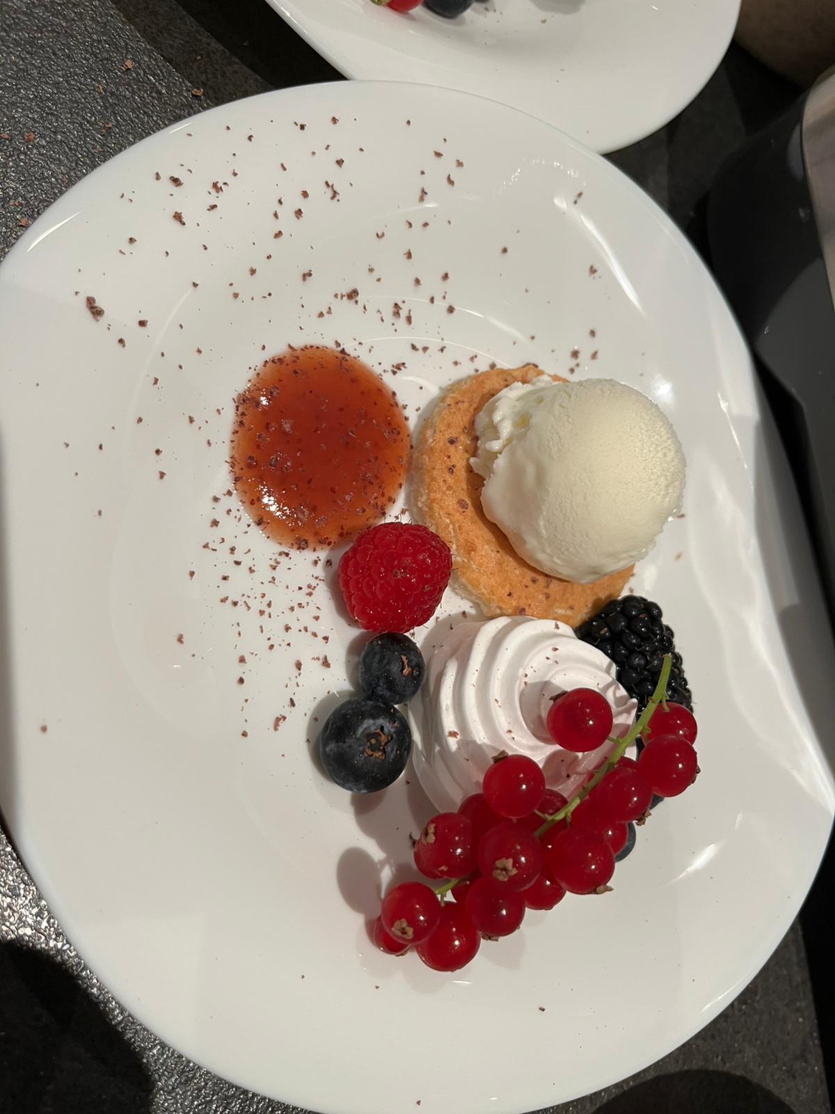 Miserable (amandelgebak), yoghurtijs, merengue, aardbeiencoulis en vers fruit